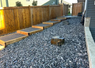 walkway in a backyard with lots of drainage rocks everywhere