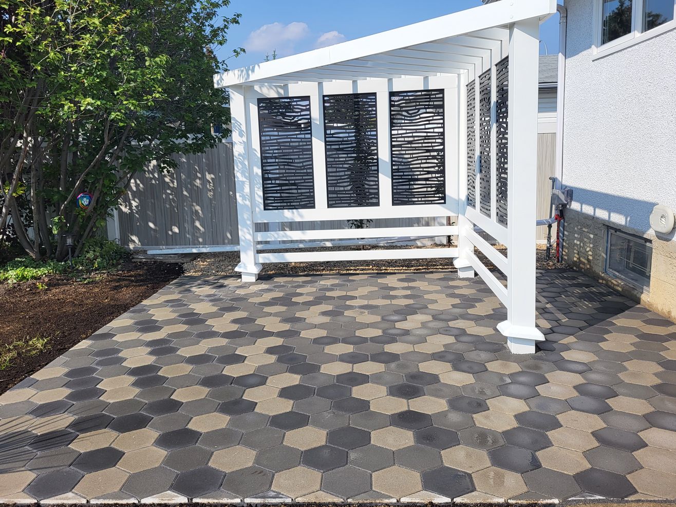 tiles and decorative fence installed in a backyard by Lush Landscaping in Edmonton