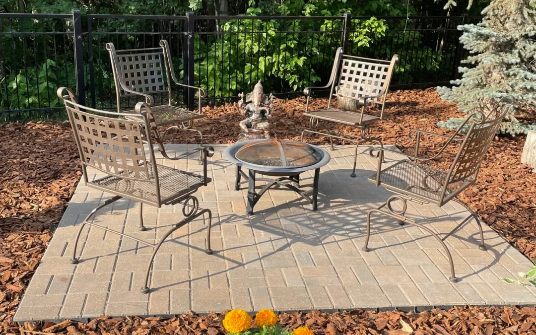 hardscape patio in a backyard with a table and chairs on it done by Lush Landscaping in Edmonton AB