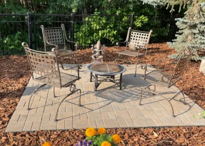 hardscape patio in a backyard with a table and chairs on it done by Lush Landscaping in Edmonton AB