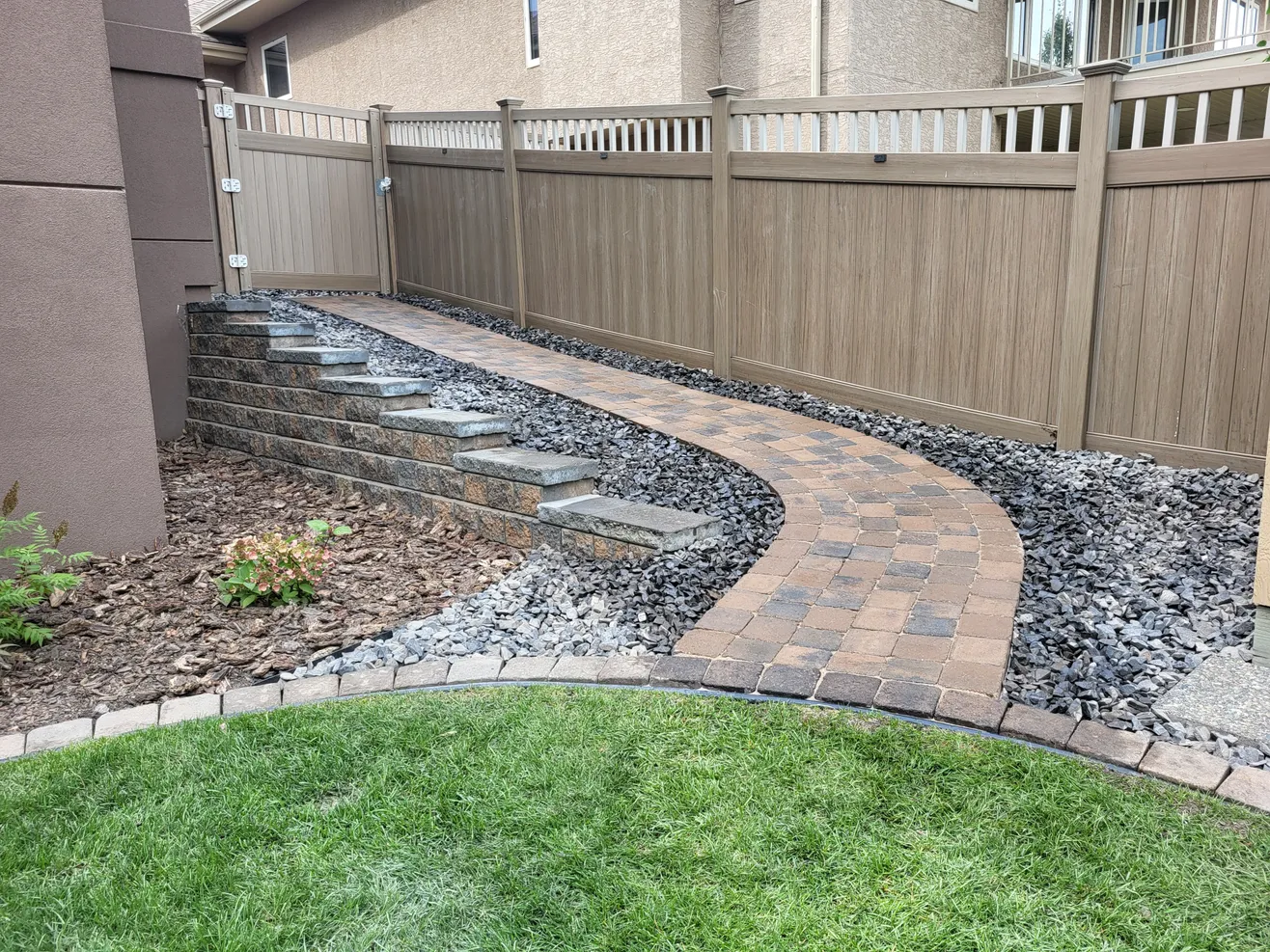 Backyard with a stone walking path by Lush Landscaping a backyard with a stone walking path by Lush Landscaping