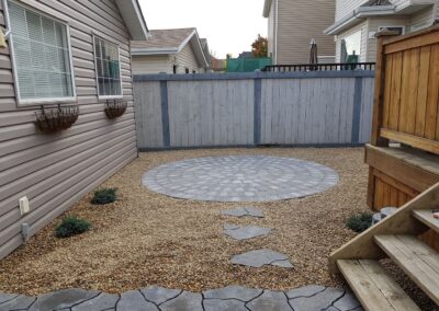 stone walking path and circular backyard patio by Lush Landscaping