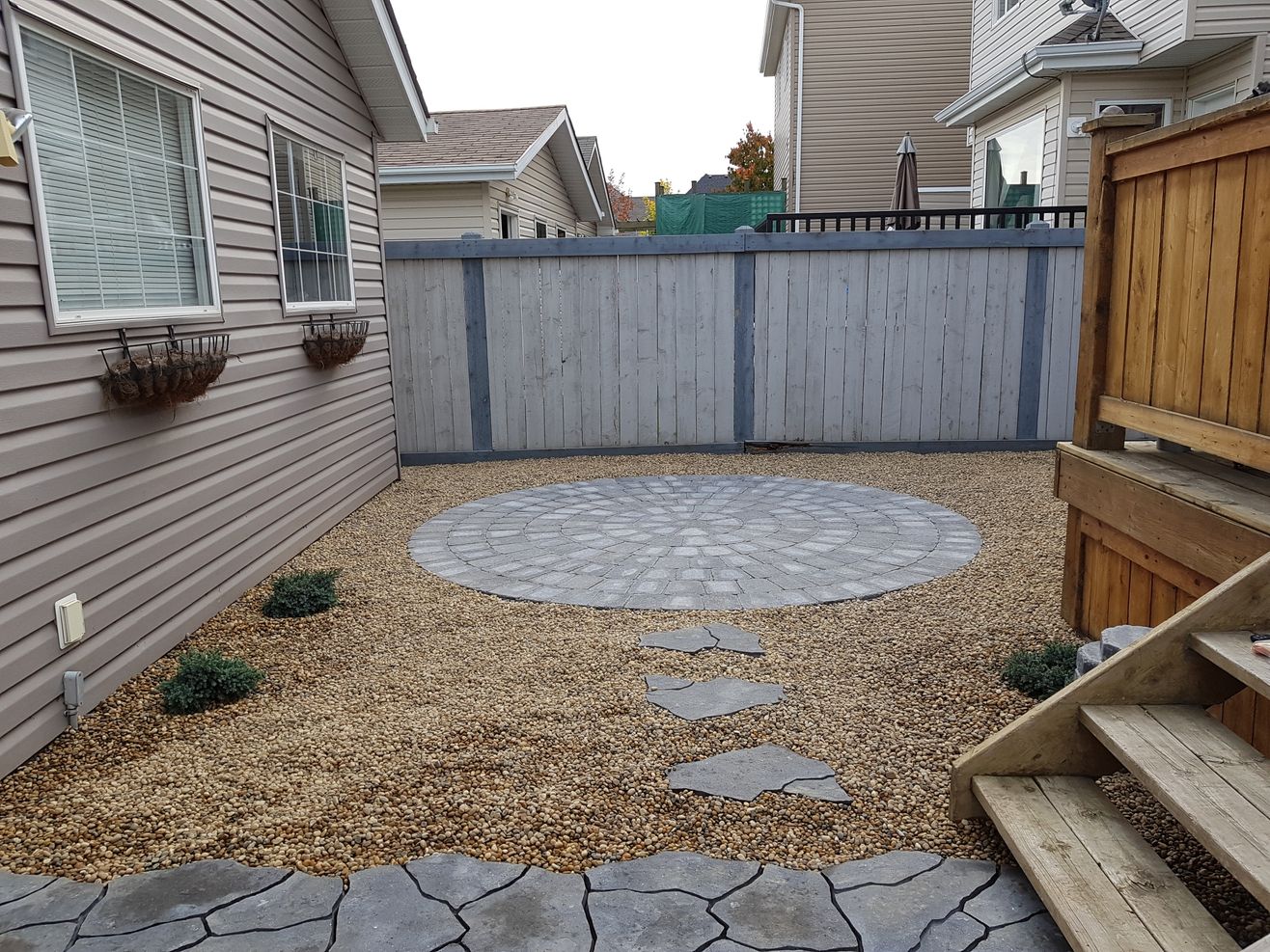 stone walking path and circular backyard patio by Lush Landscaping