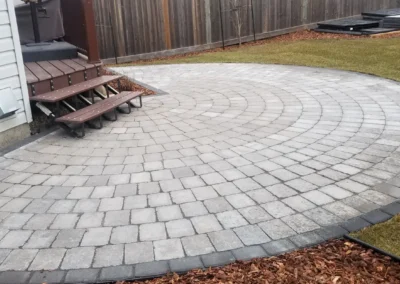 a circular patio in a backyard by Lush Landscaping in Edmonton