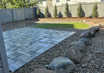 Decorative boulders and a new stone patio built by Lush Landscaping