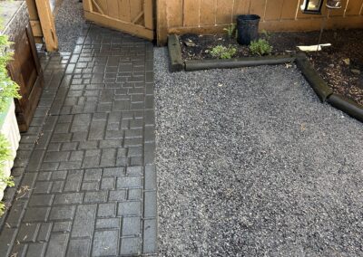 Stone walkway and low maintenance rocks in a backyard by Lush Landscaping