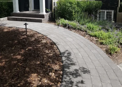 a walkway in front of a nice house that was built by Lush Landscaping in Alberta