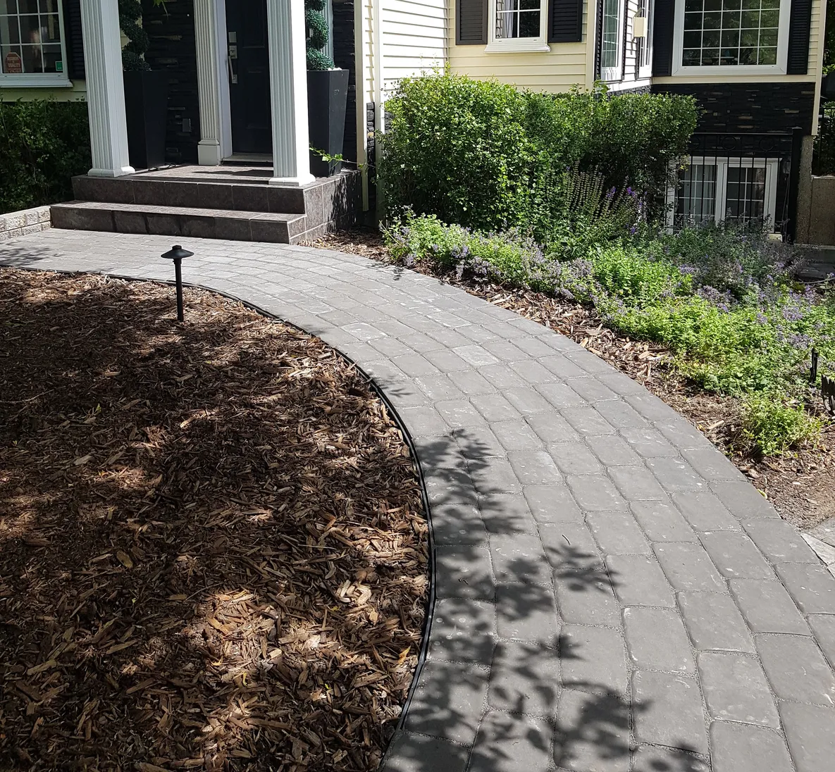Walkway in front of a nice house built by Lush Landscaping in Alberta a walkway in front of a nice house that was built by Lush Landscaping in Alberta