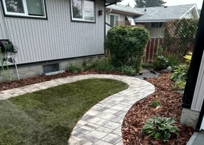 a stone walkway built in a backyard by Lush Landscaping