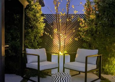 two patio chairs in an illuminated backyard seating area