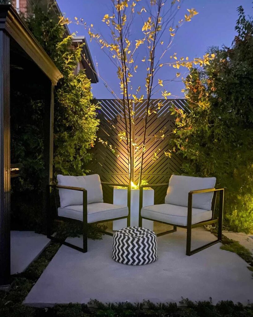 two patio chairs in an illuminated backyard seating area