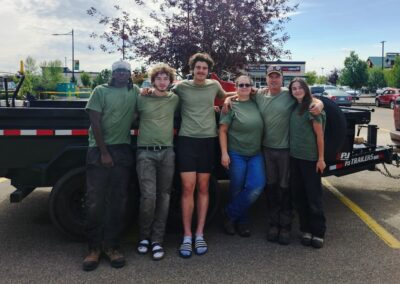 Lush Landscaping team in Edmonton Alberta Canada in a parking lot standing in front of their work trailer getting ready to do landscaping work